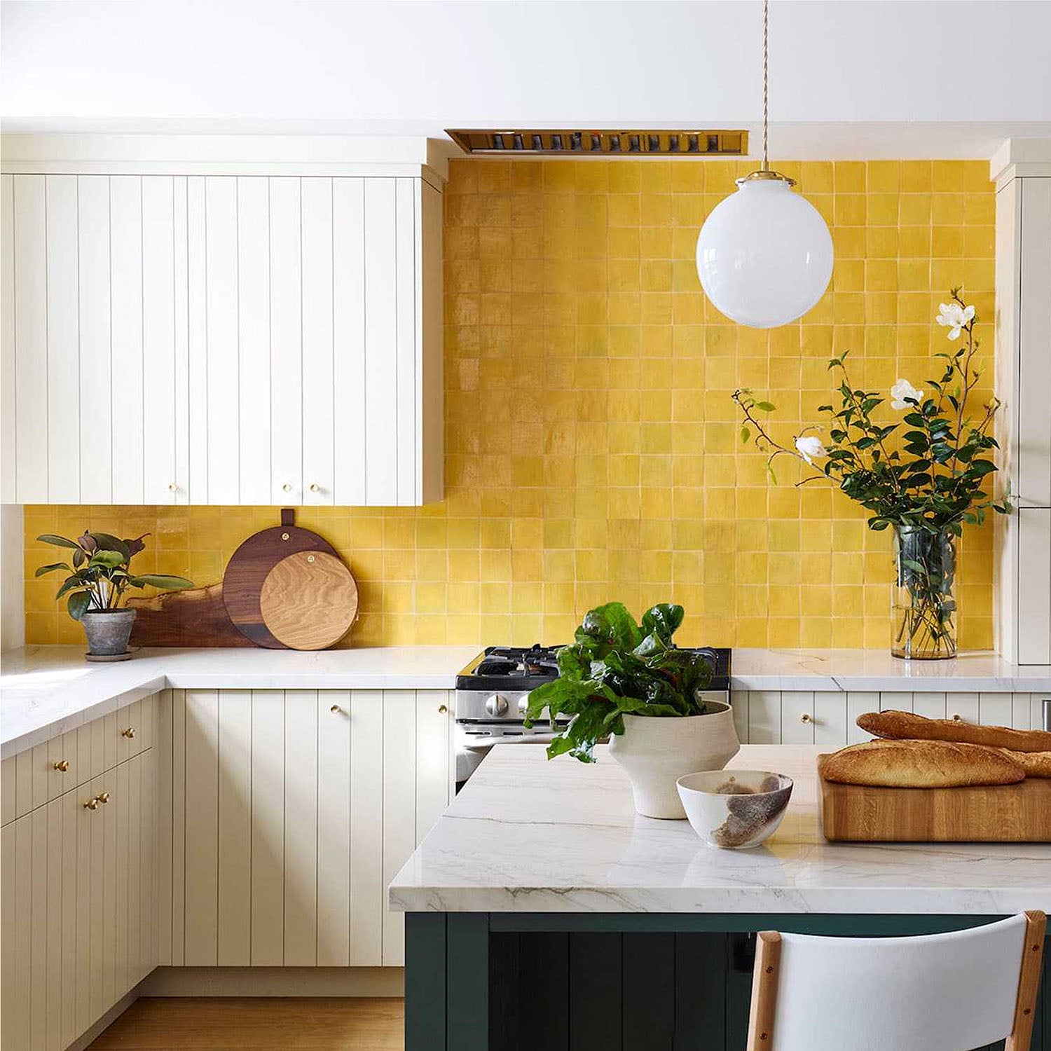 Modern kitchen with yellow tiled backsplash and white countertops