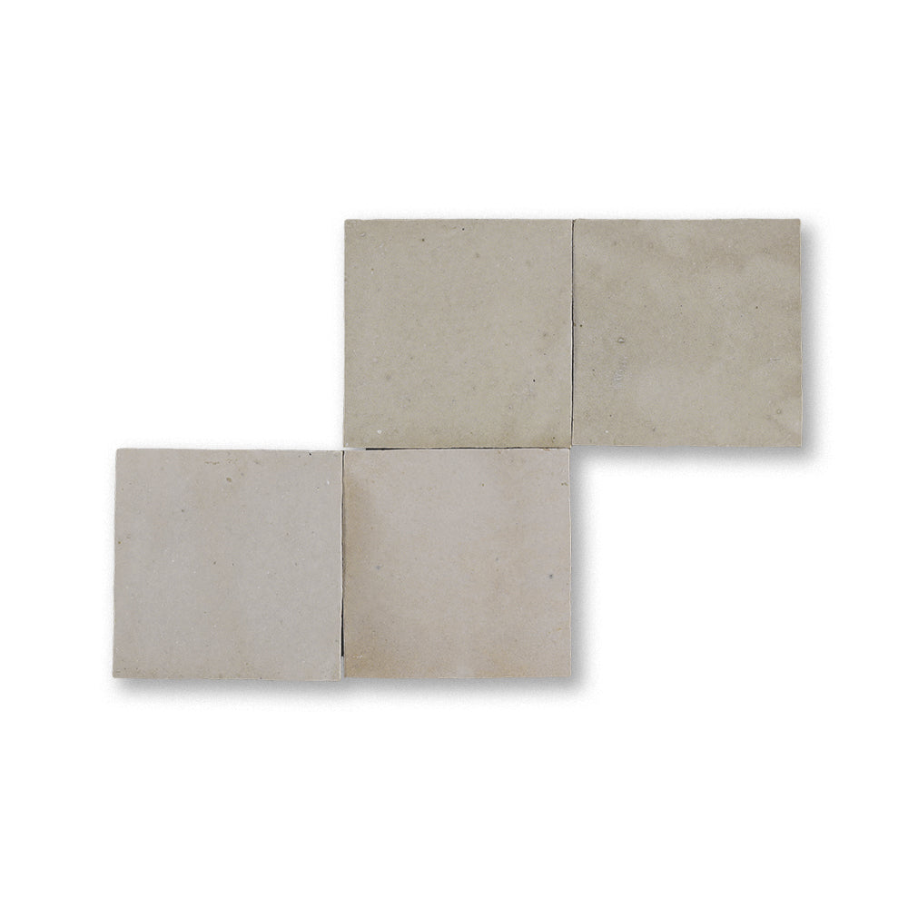Set of four beige tiles arranged in a corner pattern on a white background