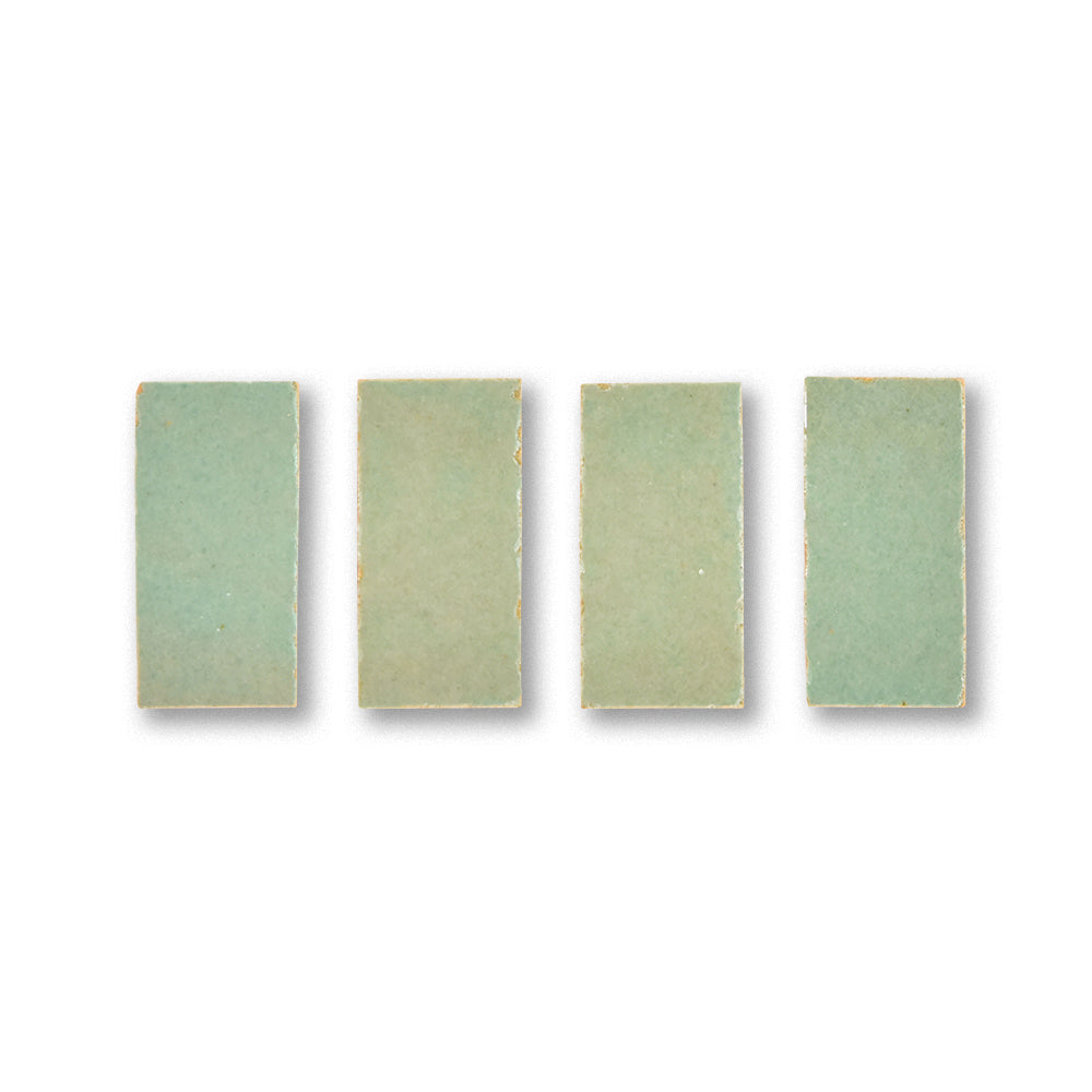 Four rectangular green tiles with a subtle pattern on a white background