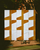 Geometric patterned wall art with brown and white tiles outdoors